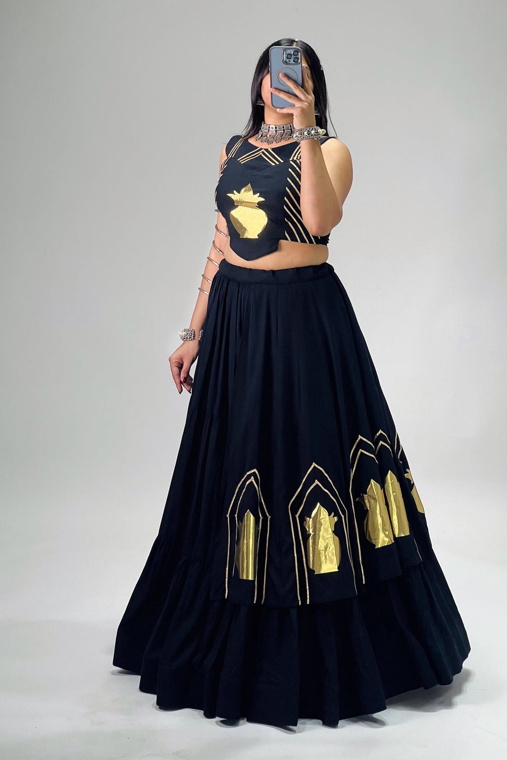 Close-up of black Navratri lehenga choli with golden Kalash and Gota Patti work