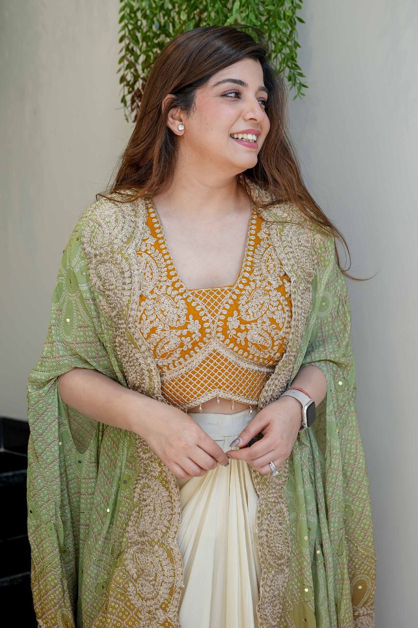Close-up of Indian dhoti set showing embroidered mustard blouse with cording work and Bandhani shrug