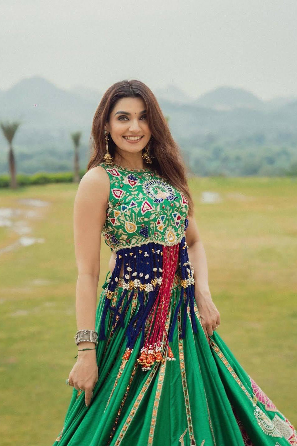 Green lehenga choli featuring colourful printed bodice and traditional detailing