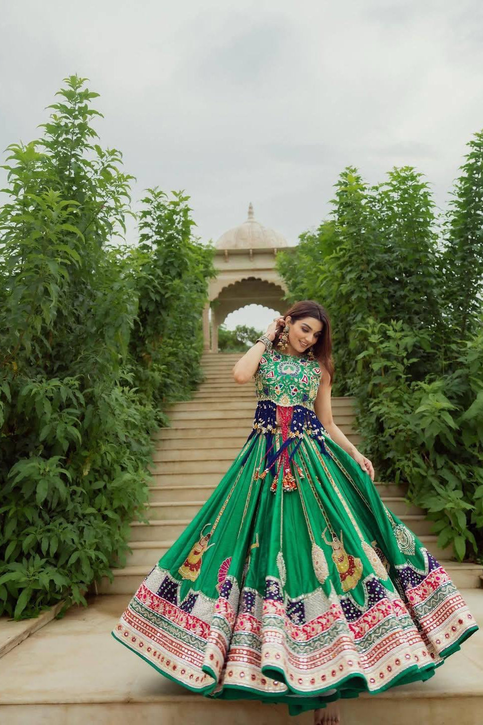 Close-up of green lehenga choli showing the printed bodice and hanging decorative details