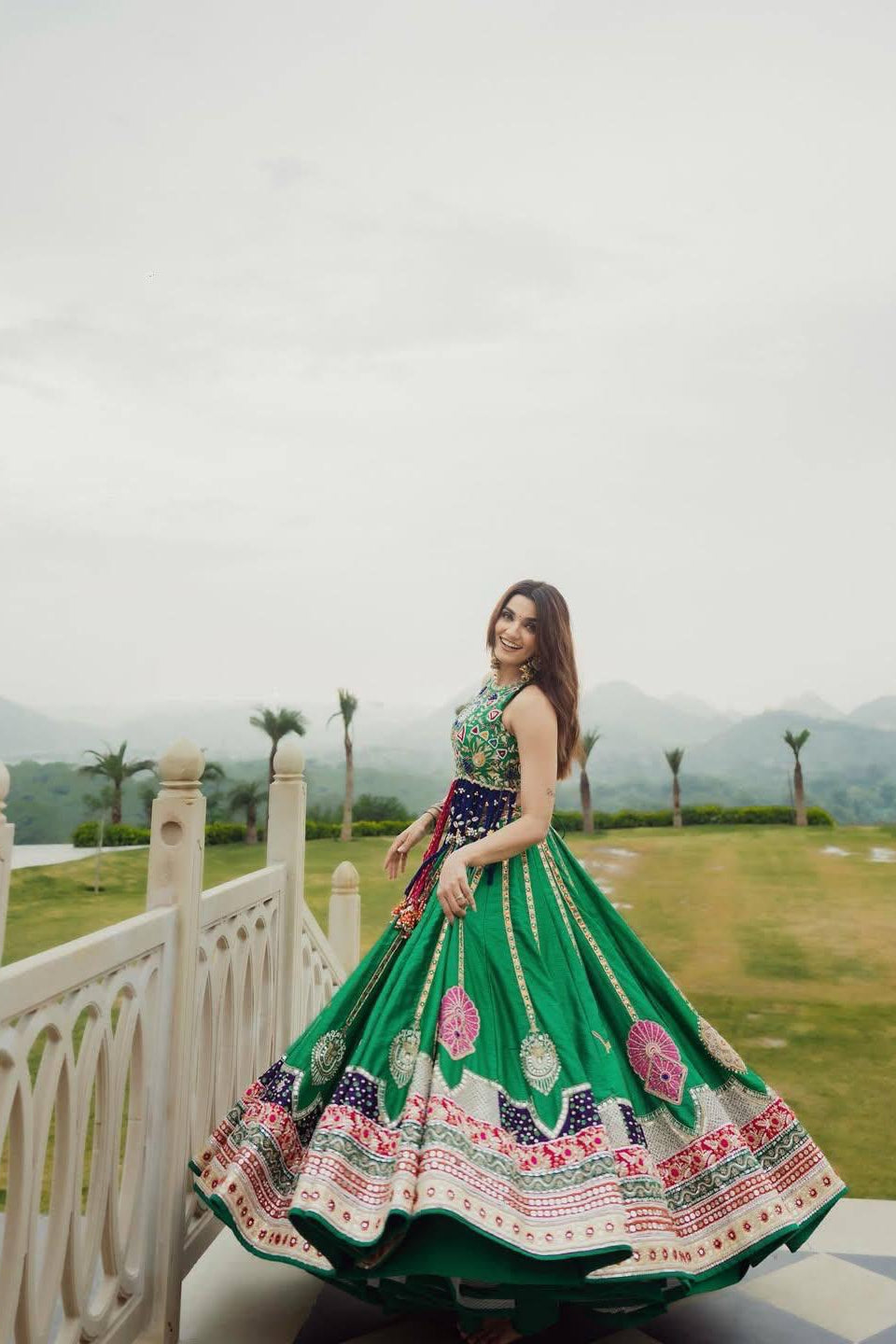 Green partywear lehenga choli with colourful print styled for a festive occasion