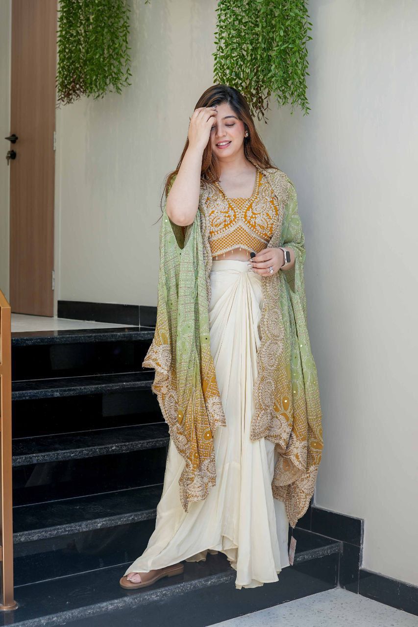 Full-length Indian dhoti set styled with ivory dhoti and sage green embroidered Bandhani shrug
