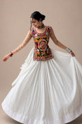 Women wearing a colorful embroidered Kediya Chaniya Choli with a white flared chaniya for Navratri Garba