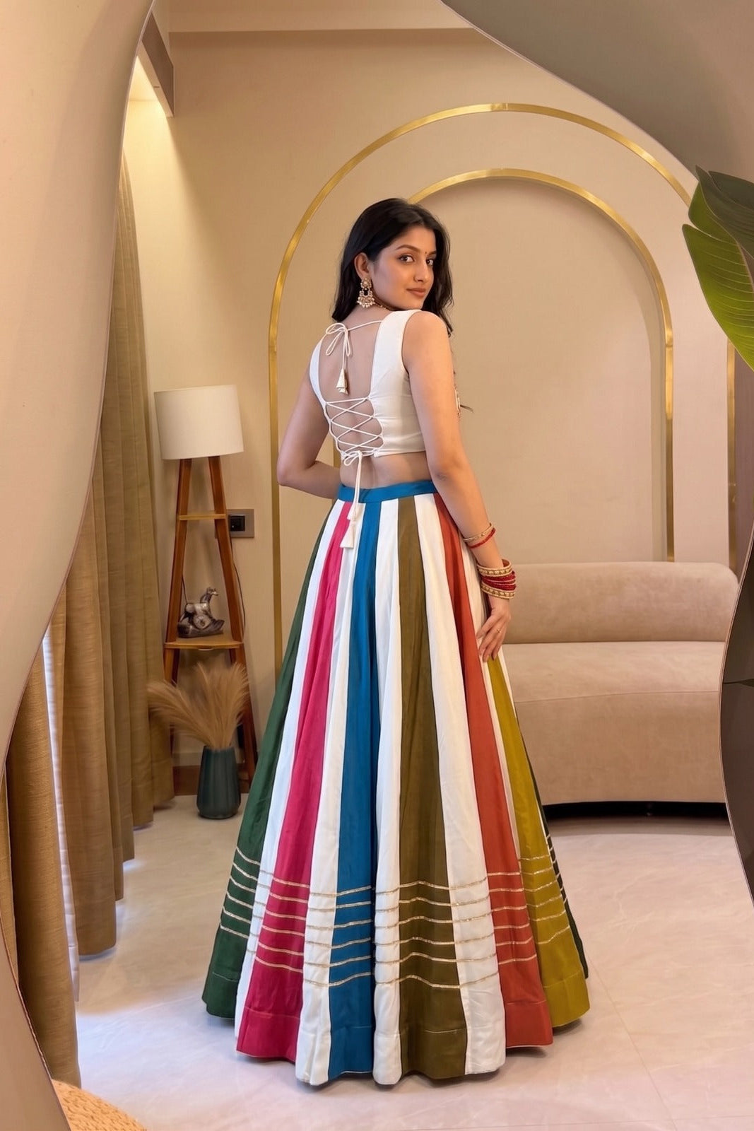 Back view of multicolor lehenga choli showing the lace-up blouse and colorful striped rayon skirt