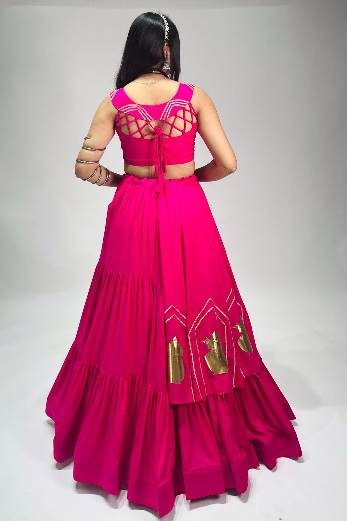 Back view of fully stitched Rani pink chaniya choli blouse with dori closure and matching flared lehenga