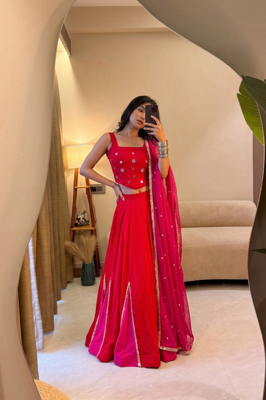 Red and pink Indian lehenga choli with mirror work for festive celebrations